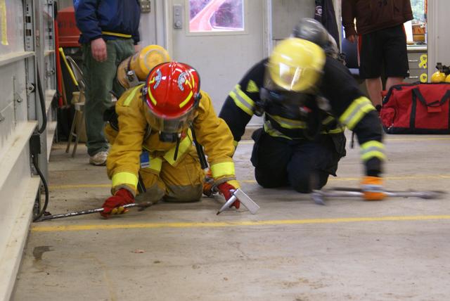 Chelsea Tremblay feels the wall while remaining in contact with her partner during a search and rescue drill conducted 10/13/2010 at the Paul Smiths fire station